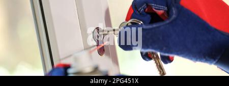 Window master repairing lock on key on window frame Stock Photo