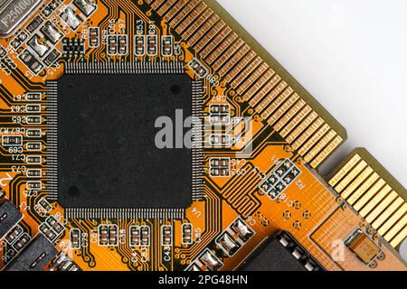 Orange printed circuit board with black chip - space for text - in middle, view from above Stock Photo