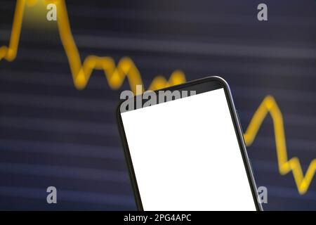 Black phone with blank mockup screen on rising stock graph. Closeup hand showing smartphone isolated white display. Online banking, Fund App use. Fina Stock Photo