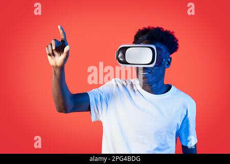 Black man in VR headset touching something invisible, click button Stock Photo