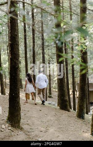 A young couple enjoying a leisurely stroll through a tranquil forest Stock Photo