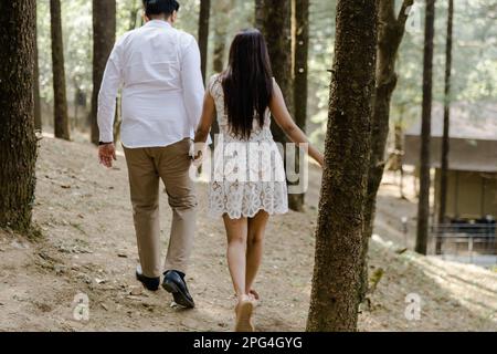 A young couple enjoying a leisurely stroll through a tranquil forest Stock Photo