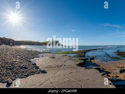 Kimmeridge bay scene with Kimmeridge Clay Formation going out to sea and sunstar on a clear blue sky with ww2 type 25 pillbox and clavell tower Stock Photo