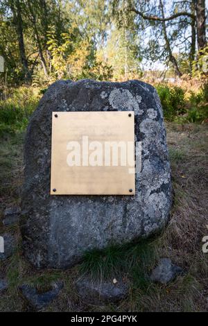 Empty golden plate on a rock in nature. Mockup with textured surface. Stock Photo