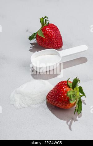 Natural strawberry collagen protein powder for skin regeneration in a scoop. Plant based. Hydrolyzed. The concept of food additives. Stock Photo