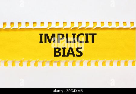 Implicit bias symbol. Concept words Implicit bias on yellow paper. Beautiful yellow table white background. Business psychology implicit bias concept. Stock Photo