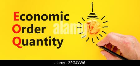 EOQ economic order quantity symbol. Concept words EOQ economic order quantity on paper on beautiful yellow background. Orange light bulb icon. Busines Stock Photo