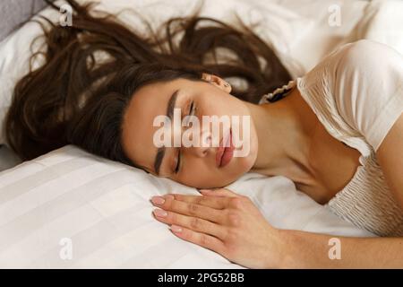 Portrait of a beautiful young woman who sleeps sweetly on the bed. Lying on a soft pillow close-up. Side view. Stock Photo