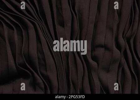 plain black fabric pleated with lines as a background, the fabric is ironed with stripes Stock Photo