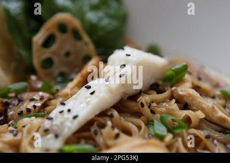 Exotic sea bass dish prepared with Asian noodles and black sesame seeds. Delicious haute cuisine in a sea food restaurant Stock Photo