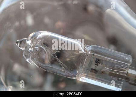 Close-up of a burned-out malfunctioning incandescent light bulb with broken wolfram filament inside a glass lamp. For 230V and consuming 57W of power. Stock Photo