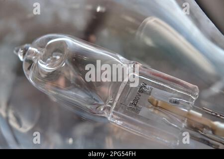 Close-up of a burned-out malfunctioning incandescent light bulb with broken wolfram filament inside a glass lamp. For 230V and consuming 57W of power. Stock Photo