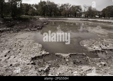 Ecological catastrophy. Drying lake in city park. Dry swamp lake disappears, idea and concept of environmental conservation, drought, warming and cata Stock Photo