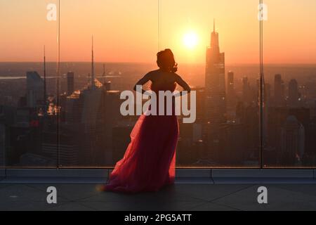 An influencer creates content during sunrise from the Edge observation deck at Hudson Yards on the first day of spring on March 20, 2023 in New York C Stock Photo