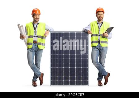 Male engineers in safety vests leaning on a solar panel isolated on white background Stock Photo