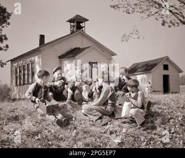 1950s SEVEN FARM BOYS SITTING IN A GROUP TOGETHER OUTSIDE COUNTRY SCHOOLHOUSE EATING LUNCHES NEAR TIDIOUTE PENNSYLVANIA USA - s3743 HEL001 HARS LIFESTYLE HISTORY RURAL NATURE COPY SPACE FRIENDSHIP FULL-LENGTH MALES B&W SCHOOLS GRADE HAPPINESS EXTERIOR LOW ANGLE NUTRITION PA SEVEN FALL SEASON NEAR PRIMARY SCHOOLHOUSE COMMONWEALTH CONNECTION 7 CONSUME CONSUMING FRIENDLY KEYSTONE STATE LUNCHES NOURISHMENT SUPPORT GRADE SCHOOL GROWTH JUVENILES TOGETHERNESS AUTUMNAL BLACK AND WHITE CAUCASIAN ETHNICITY FALL FOLIAGE OLD FASHIONED Stock Photo