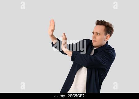 Scared young man on light background Stock Photo