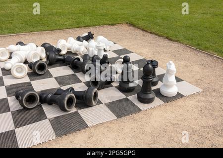 Chessboard and chess pieces on the grass in the garden,playing wooden chess pieces, business teamwork competition games concept, leadership hand of bu Stock Photo