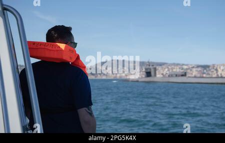 230316-N-UM222-0065 NAPLES, Italy (March 16, 2022) Electrician's Mate 1st Class Frederick Waldroup, assigned to Submarine Group Eight, watches the Ohio-class guided missile submarine USS Florida (SSGN 728) during a brief stop for personnel (BSP) in the Bay of Naples, Naples, Italy, March 16, 2023. The stop demonstrates the strength of the U.S.-Italy partnership as the two nations continue working together for a secure, stable & prosperous Europe. (U.S. Navy photo by Mass Communication Specialist 2nd Class Jasmine Suarez) Stock Photo