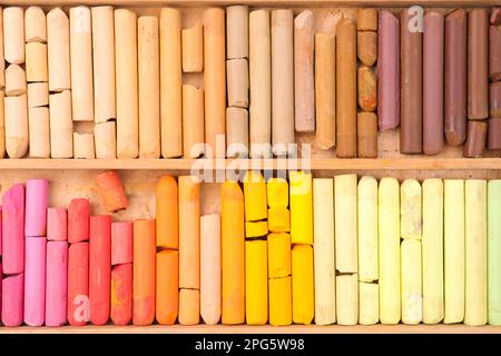 Set of soft pastels in wooden box as background, top view. Drawing material Stock Photo