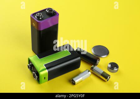 Different types of batteries on yellow background Stock Photo