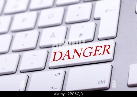 High end aluminium keyboard with DANGER word in red on it. Danger and alert Stock Photo
