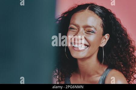 Happy looks good on everyone. a beautiful young woman wearing makeup while posing against a pink background. Stock Photo