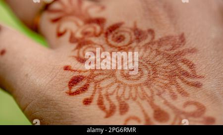Muslim woman with henna tattoo on her hands outdoors, smile face with Hijab closeup Stock Photo