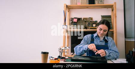 Repairs and diagnostics breakdowns of laptop in professional service center. Electronic master detach detail of laptop in workshop using screwdriver Stock Photo