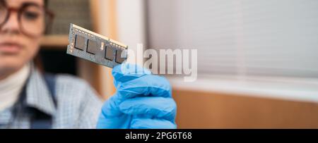 Laptop repair engineer holding random access memory Ram in computer repair service. Professional laptop repair concept Stock Photo