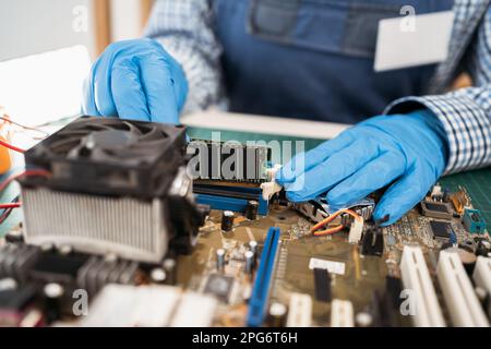 Installing random access memory into PC. Computer service engineer technician workplace repairing fixing broken components upgrade system, motherboard Stock Photo