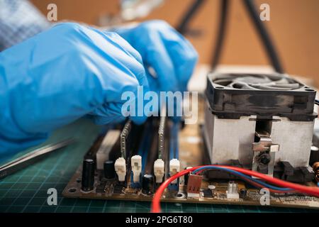 Installing random access memory into PC, installing memory on a computer motherboard, woman repairing computer hardware in service center. Stock Photo