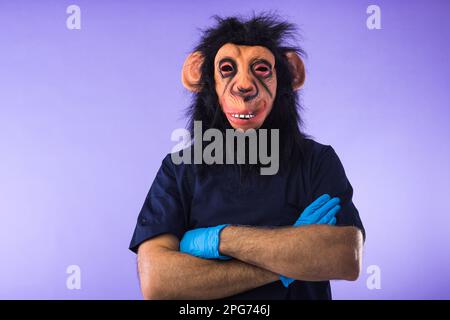 Disguised person in a monkey mask and doctor's outfit, with arms crossed, on purple background. MONKEYPOX, Pandemic, virus, epidemic, Nigeria and smal Stock Photo