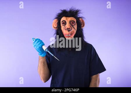 Disguised person in a monkey mask and doctor's outfit, holding a laboratory pipette, on purple background. MONKEYPOX, Pandemic, virus, epidemic, Niger Stock Photo