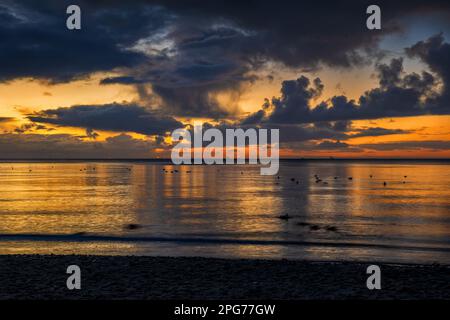 Picturesque sunrise at the Baltic Sea with stormy clouds in the sky and sunlight reflection in water, northern Poland. Stock Photo