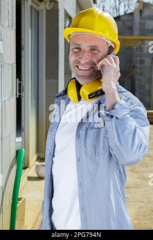 bussy engineer supervisor talking on cell phone outdoors Stock Photo
