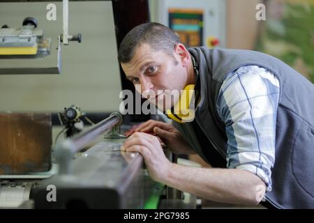 metalworker operating tool machine in manufacturing workshop Stock Photo