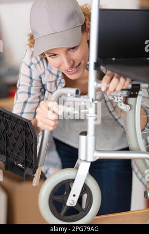 woman assembling a wheelchair in the workshop Stock Photo