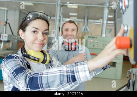 apprentice using computer control panel in factory Stock Photo