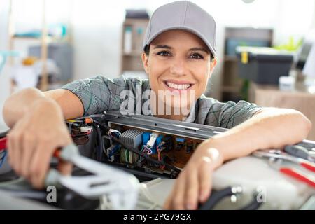 female engineer or tech repairs electronic device Stock Photo