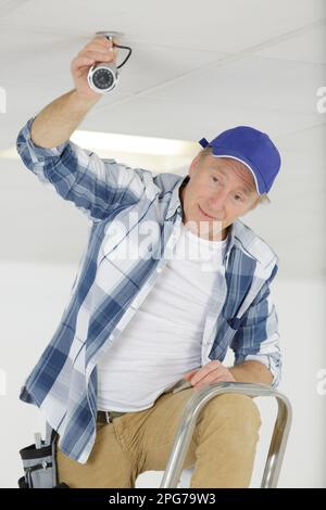 close-up of technician adjusting cctv camera on wall Stock Photo