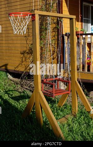 wooden homemade swing in the village, russia Stock Photo