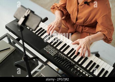 High angle view of teacher teaching her student to play piano and recording lesson online Stock Photo
