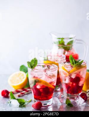 Raspberry lemonade in glasses with fresh berries and mint leaves Stock Photo