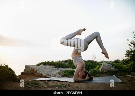 Calm slim woman practicing yoga and meditating, enjoying training on beach  near sea, exercising Stock Photo by Prostock-studio