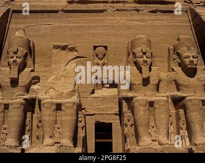 Four seated colossi of long-ruling 19th Dynasty New Kingdom Pharaoh, Ramesses II, each 20m (66 ft) high, dominate the front of the Great Temple he built in 1255 BC at Abu Simbel in ancient Nubia, Egypt.  The two massive rock temples on the western bank of Lake Nasser were relocated in the 1960s above the Aswan High Dam reservoir, to stop them being engulfed by its rising waters. Stock Photo
