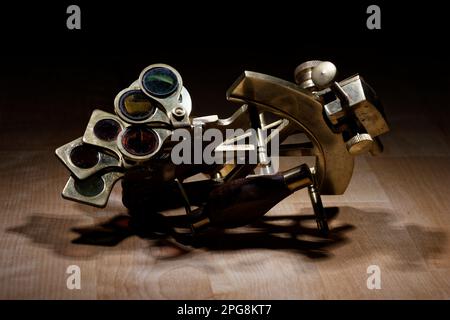 old sextant, spyglass, circle and compass lying on wooden table Stock Photo