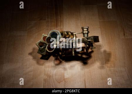 old sextant, spyglass, circle and compass lying on wooden table Stock Photo