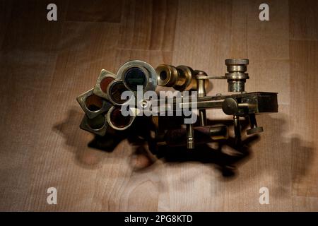 old sextant, spyglass, circle and compass lying on wooden table Stock Photo