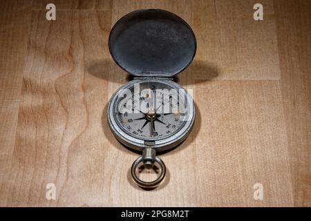 Open old vintage compass on wooden table Stock Photo